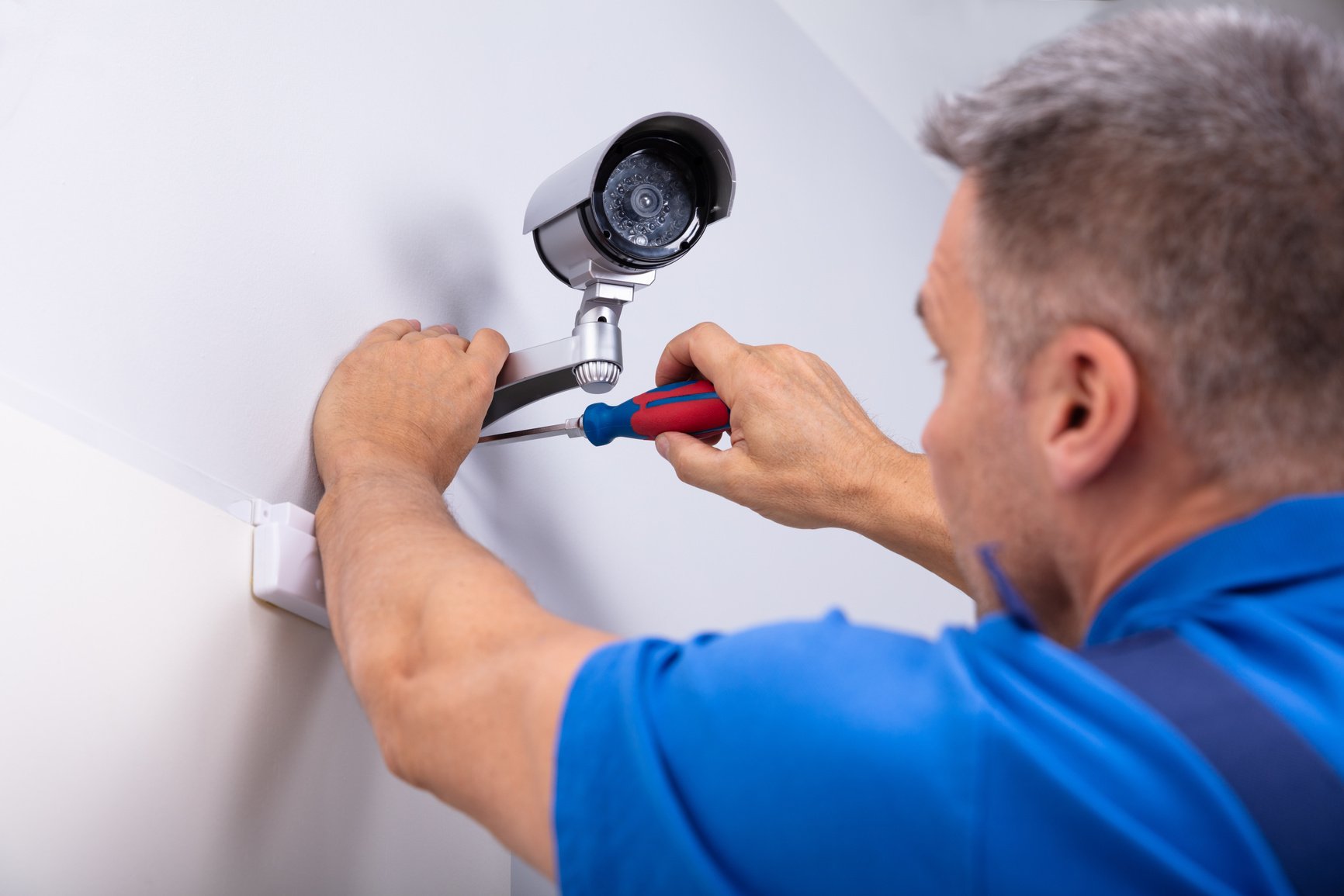 Technician Fixing Security Camera